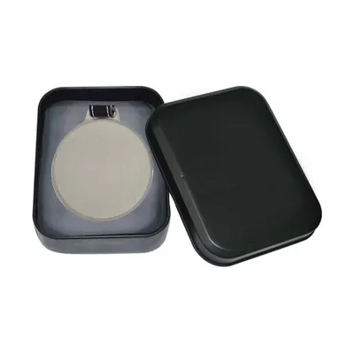 Metal luggage tag on a leather strap in a tin box